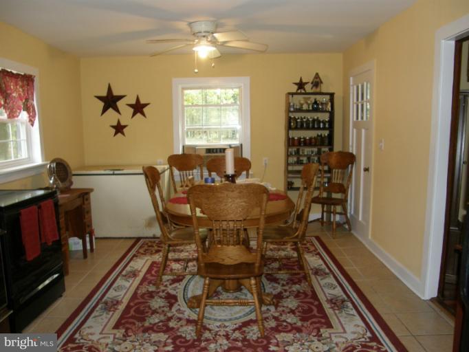 6885 Harmony Road Preston, MD 21655 - Photo 13 of 22 a dining room with furniture a rug and a window