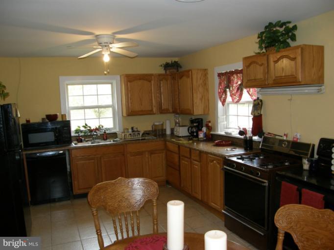 6885 Harmony Road Preston, MD 21655 - Photo 14 of 22 a kitchen with granite countertop a sink cabinets and stainless steel appliances