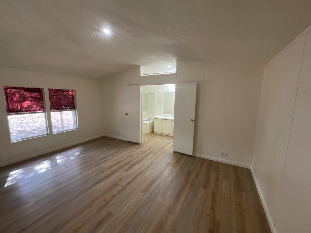 204 Overhill Road Bastrop, TX 78602 - Photo 6 of 18 an empty room with wooden floor and windows