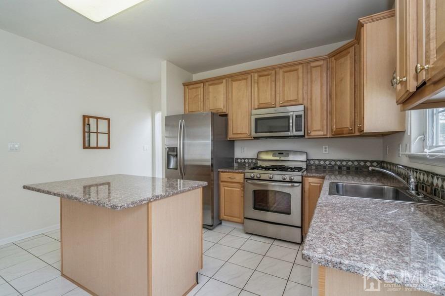 111 San Marco Road Monroe Township, NJ 08831 - Photo 15 of 31 a kitchen with stainless steel appliances granite countertop a sink stove and refrigerator