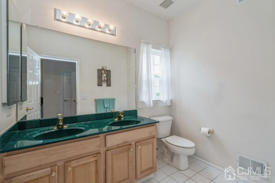 111 San Marco Road Monroe Township, NJ 08831 - Photo 27 of 31 a bathroom with a granite countertop sink a toilet a mirror and shower