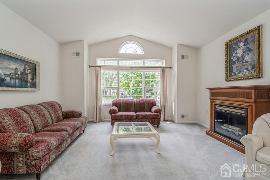 111 San Marco Road Monroe Township, NJ 08831 - Photo 7 of 31 a living room with furniture a fireplace and a floor to ceiling window
