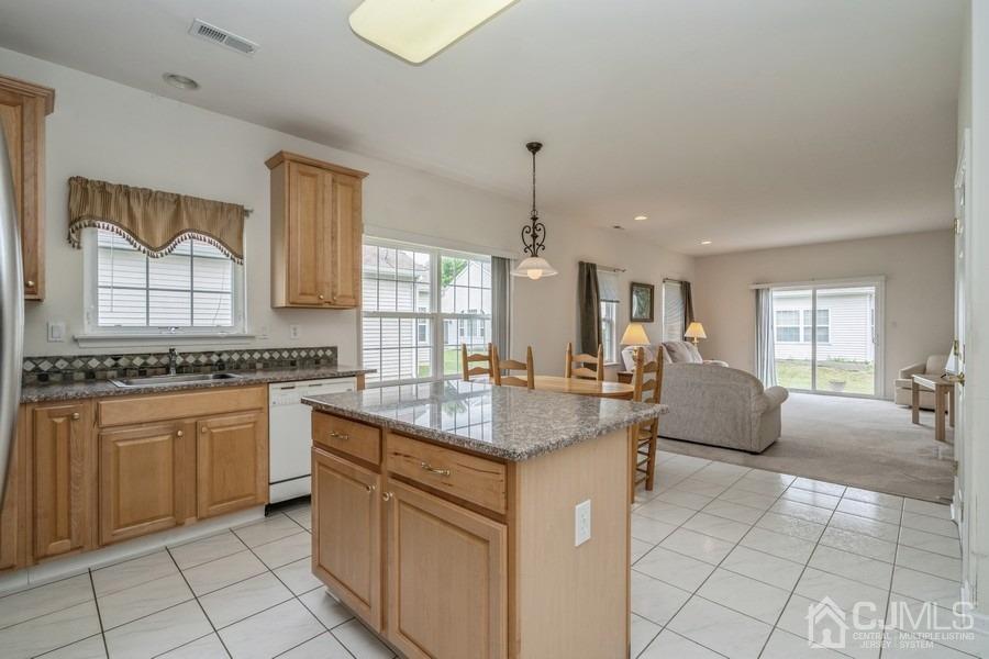 111 San Marco Road Monroe Township, NJ 08831 - Photo 10 of 31 a kitchen with granite countertop a sink white cabinets and glass table chairs