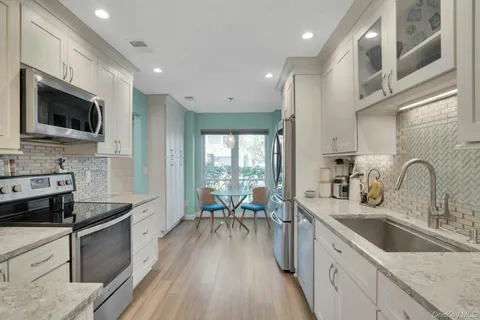 a kitchen with stainless steel appliances a stove sink microwave and cabinets