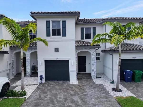 a front view of a house with a yard and a garage