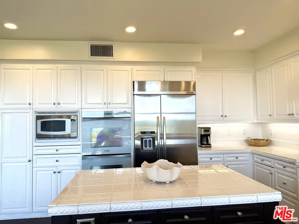 a kitchen with kitchen island granite countertop a sink appliances cabinets and counter space