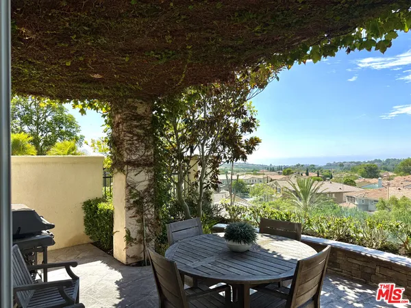 a view of a balcony with table and chairs and potted plants