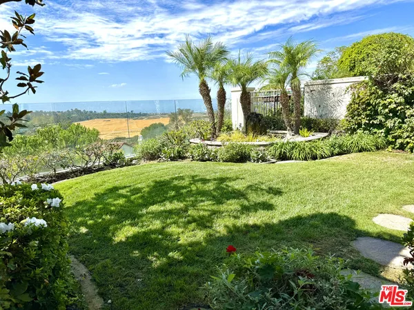 a view of a garden with a building in the background