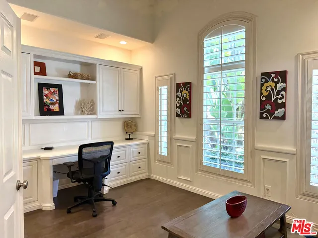 a view of a workspace with furniture and a window
