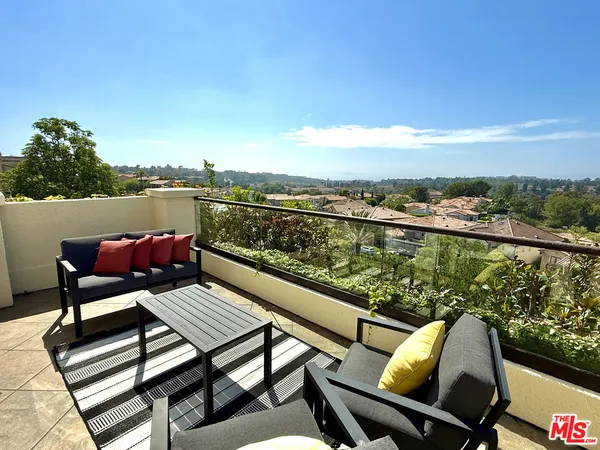 a view of a balcony with wooden floor and outdoor seating