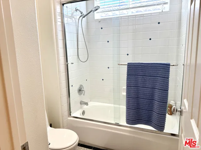 a bathroom with a granite countertop bathtub shower and toilet