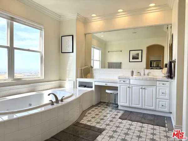 a spacious bathroom with a granite countertop sink and a bathtub