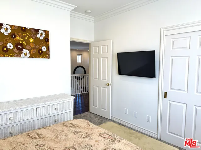 a bedroom with bed and flat screen tv