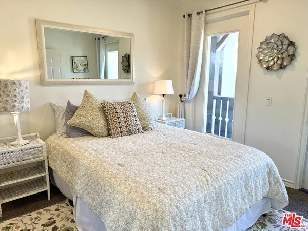 a bedroom with a bed and painting on the wall