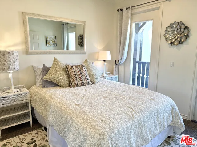 a bedroom with a bed and painting on the wall