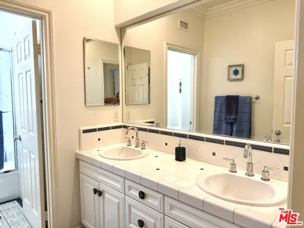 a bathroom with a granite countertop sink and a mirror