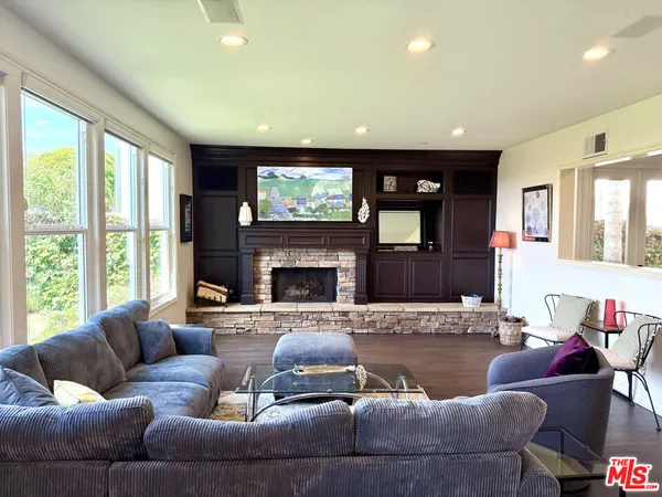 a living room with furniture a large window and a fireplace