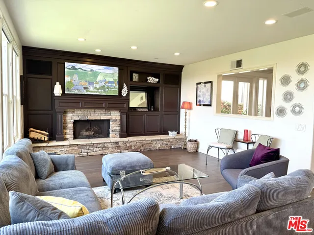 a living room with furniture a flat screen tv and a fireplace