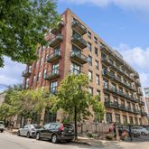 a view of a building and car parked on the side of road