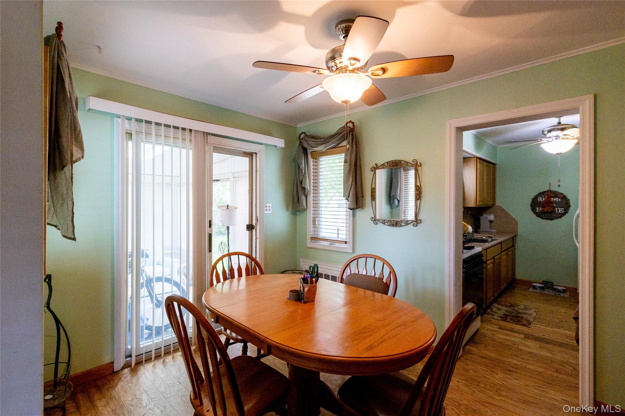90 Sunset Road Bay Shore, NY 11706 - Photo 17 of 31 Dining area featuring wood-finish flooring, a ceiling fan with integrated lighting, and direct patio access through sliding glass doors