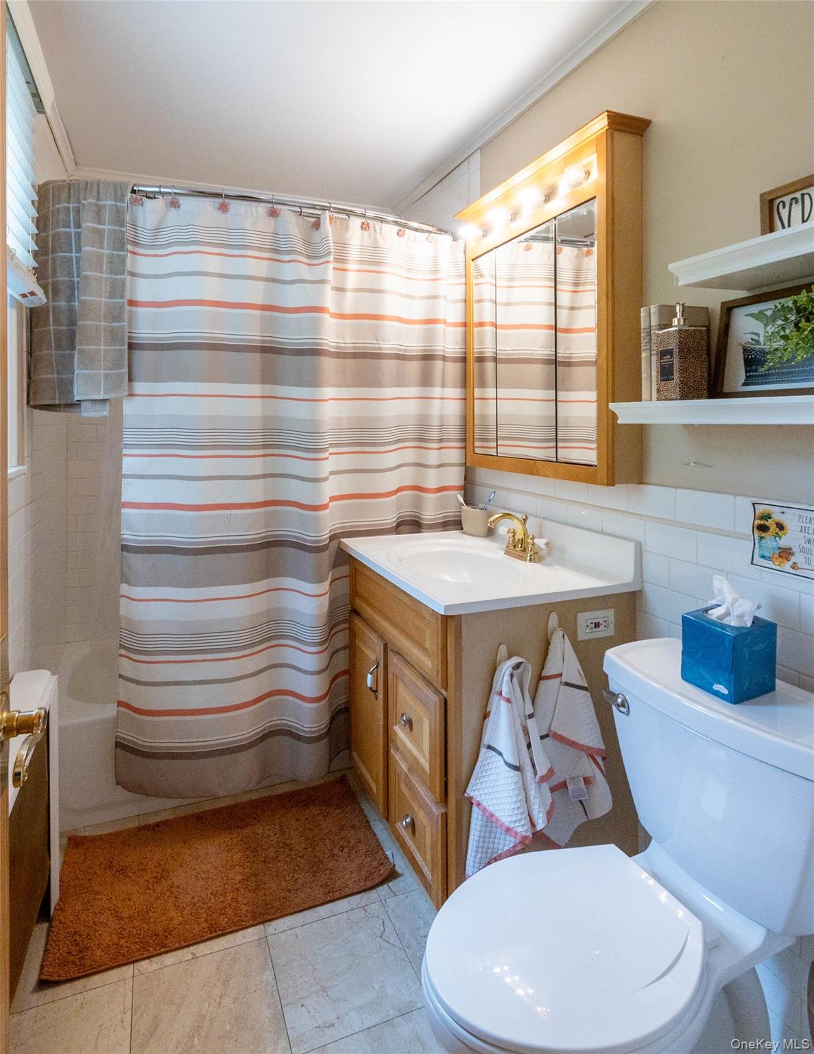 90 Sunset Road Bay Shore, NY 11706 - Photo 26 of 31 Bathroom featuring a single vanity with wood cabinetry, a white countertop, and a brass-finish faucet