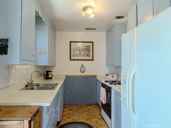 a kitchen with a sink a stove and a refrigerator
