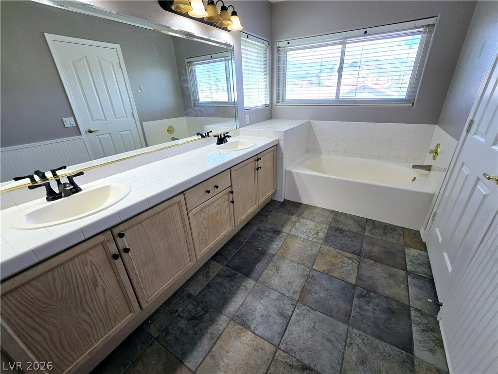 3759 Funston Way Las Vegas, NV 89129 - Photo 8 of 31 Dual vanity with ample counter space perfectly complements the relaxing soaking tub.
