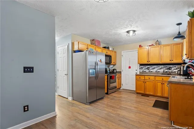 a kitchen with granite countertop stainless steel appliances a counter top space and cabinets