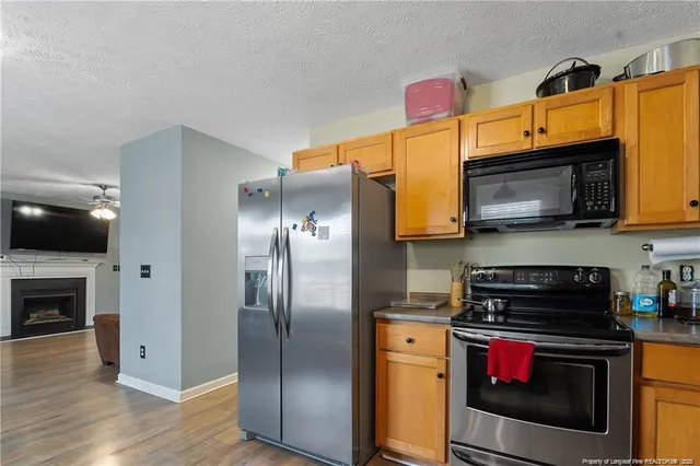 a kitchen with stainless steel appliances granite countertop a stove top oven a refrigerator and a microwave