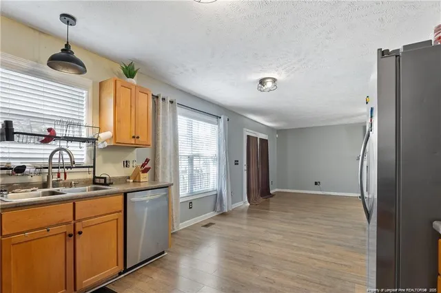 a kitchen with stainless steel appliances a refrigerator sink and cabinets