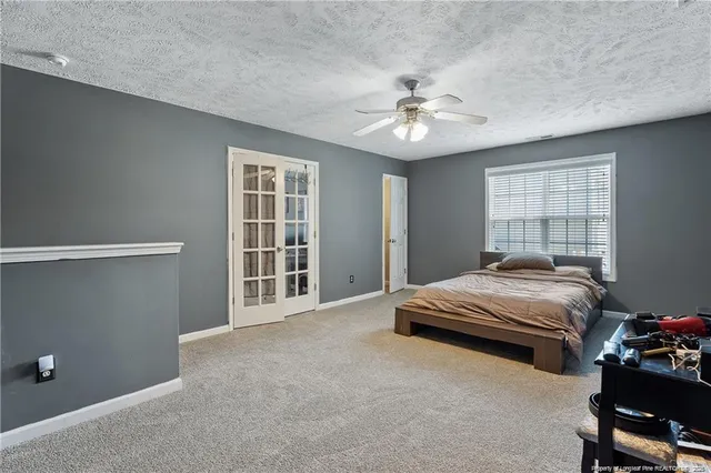 a bedroom with a bed and a ceiling fan