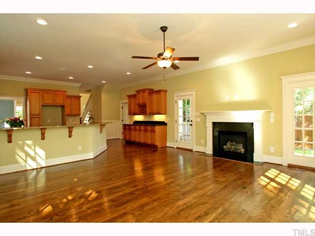 1802 Sunset Drive Raleigh, NC 27608 - Photo 5 of 12 a view of a livingroom with a fireplace a ceiling fan and wooden floor