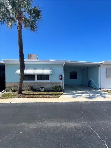 a view of a house with a yard and palm trees