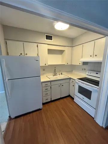 a kitchen with a refrigerator sink stove and cabinets