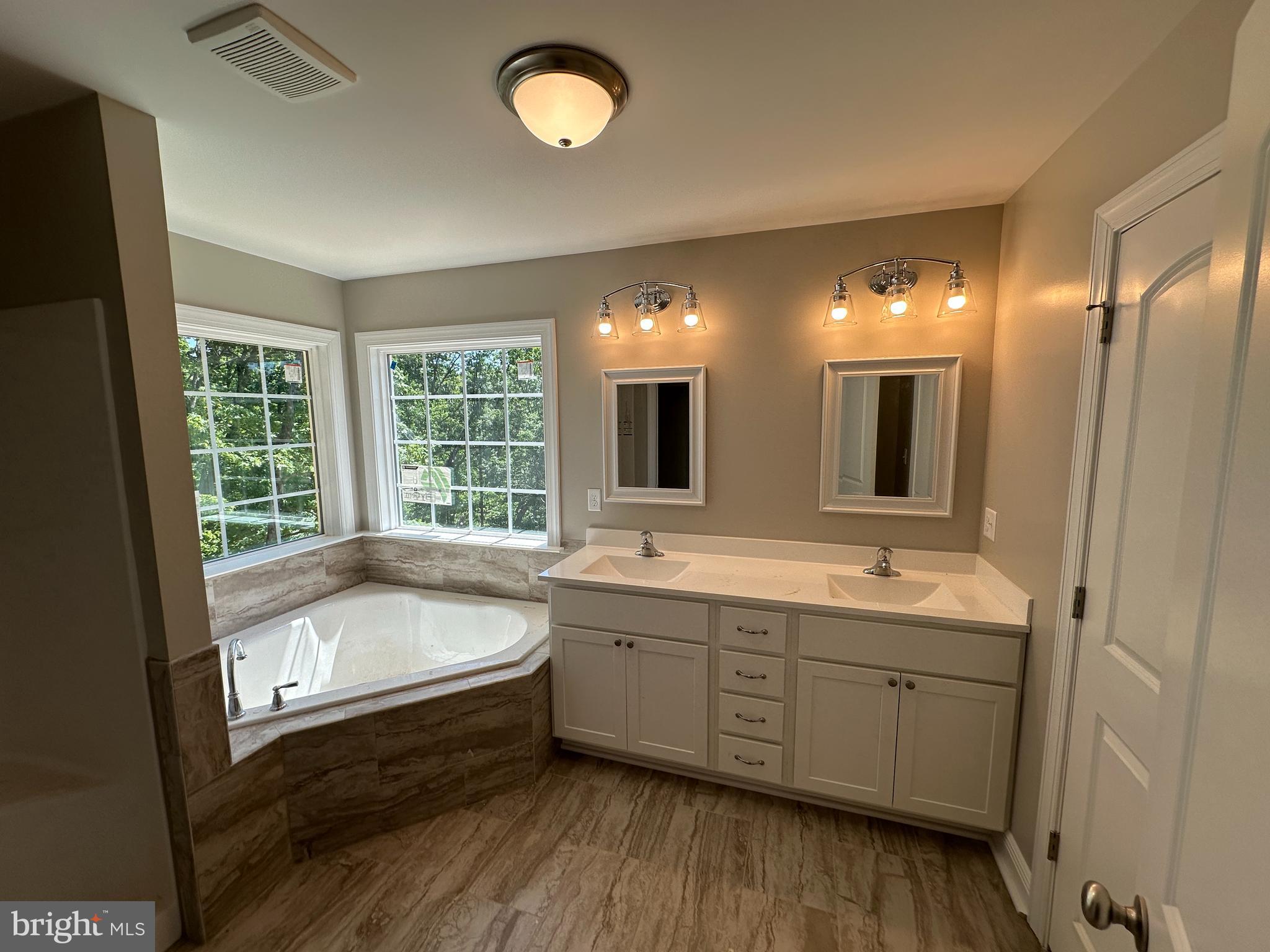 211 Inca Trail Winchester, VA 22602 - Photo 14 of 23 a bathroom with a tub a sink and a large mirror