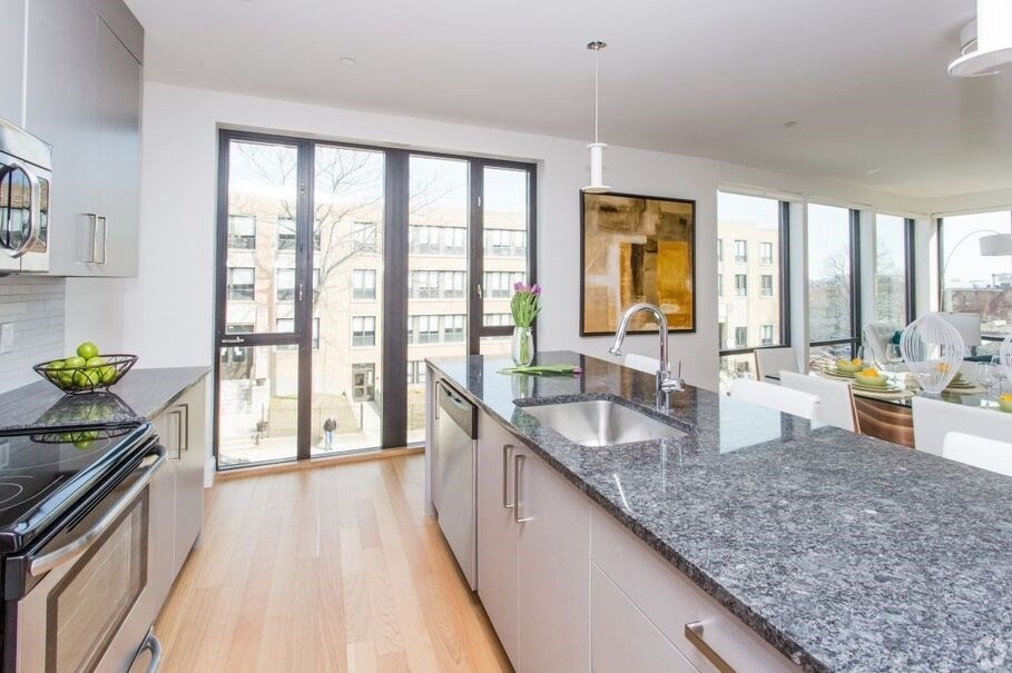 a large kitchen with granite countertop a large window and a counter space