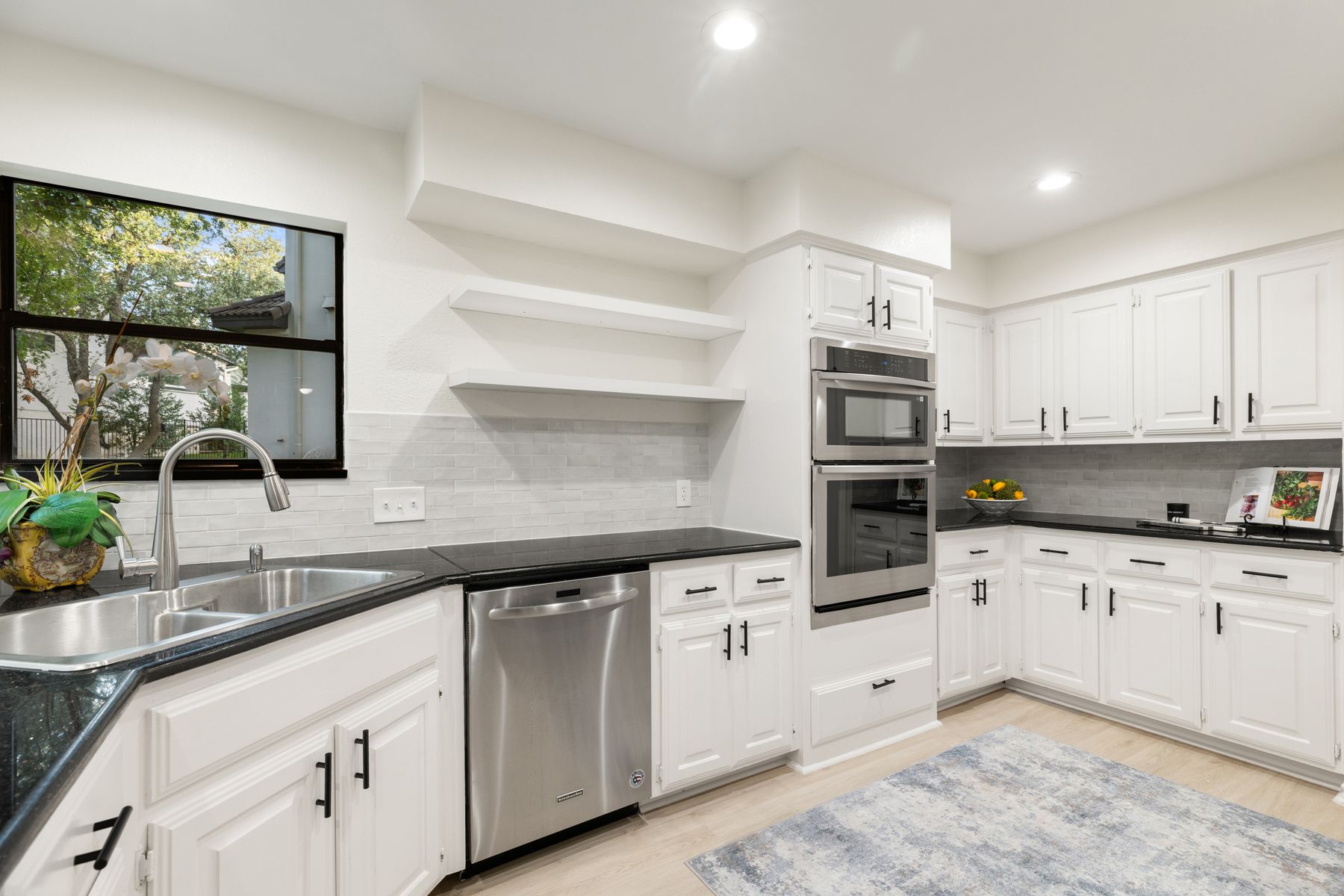 5 Valhalla Court The Hills, TX 78738 - Photo 11 of 34 The kitchen combines clean lines and practical design with abundant cabinetry, generous prep space, and a seamless connection to the breakfast area and patio. Its functional layout, walk-in pantry, and bright finishes make it equally suited for everyday living and entertaining with ease.