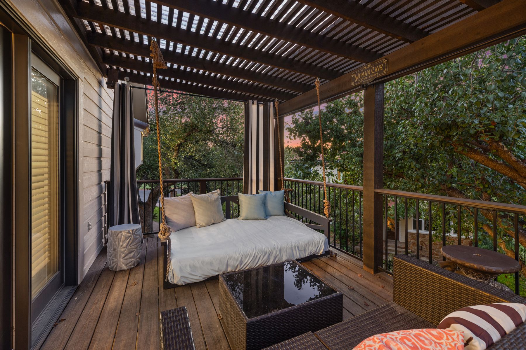 5 Valhalla Court The Hills, TX 78738 - Photo 19 of 34 Serene treetop retreat with bed swing and lounge seating—ideal for sunset unwinding.