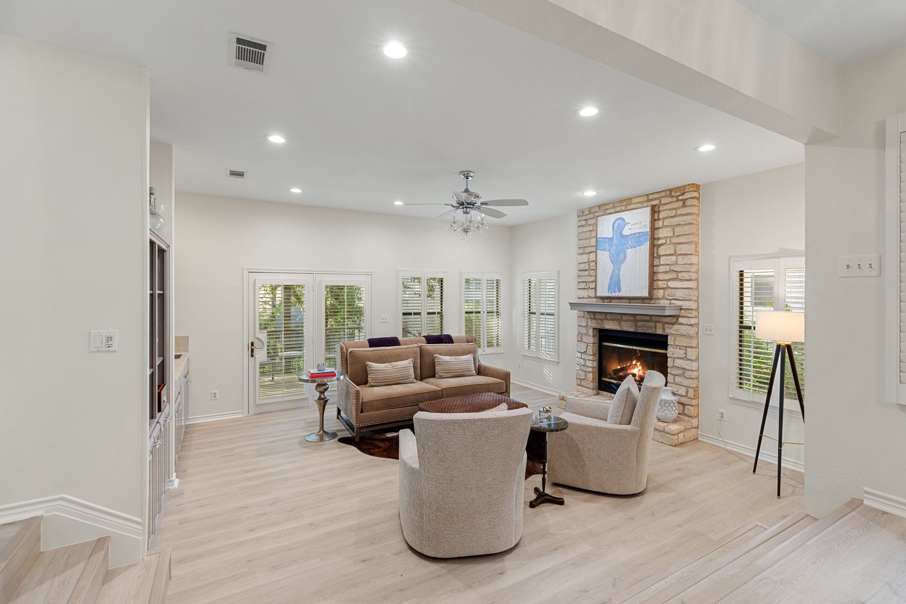 5 Valhalla Court The Hills, TX 78738 - Photo 6 of 34 Spacious living room with stone fireplace, shutters, and built-ins.