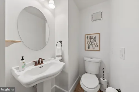 a bathroom with a sink a toilet and a window