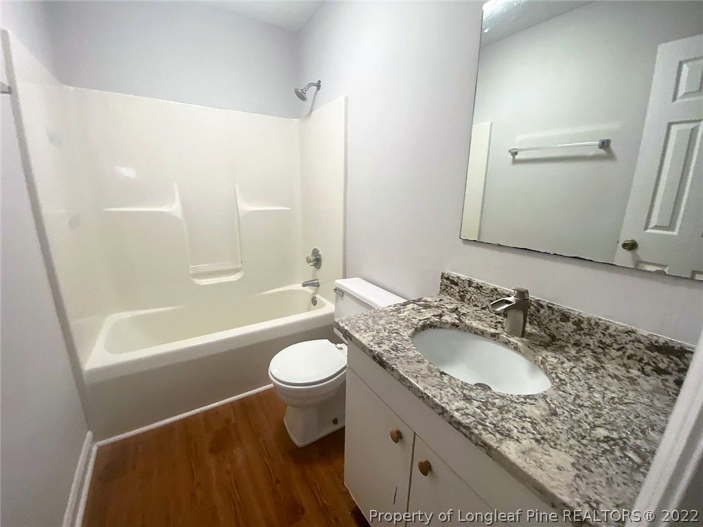 944 Flintwood Road Fayetteville, NC 28314 - Photo 22 of 50 a bathroom with a granite countertop sink toilet mirror and bathtub