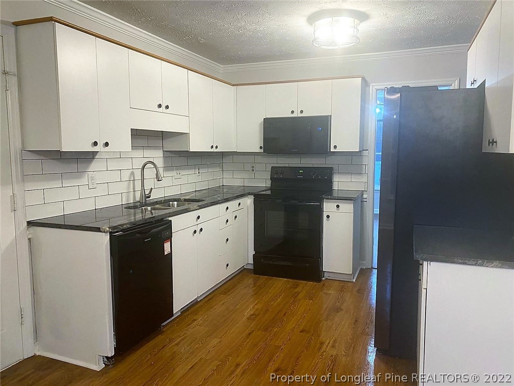 944 Flintwood Road Fayetteville, NC 28314 - Photo 23 of 50 a kitchen with stainless steel appliances granite countertop a refrigerator sink and white cabinets
