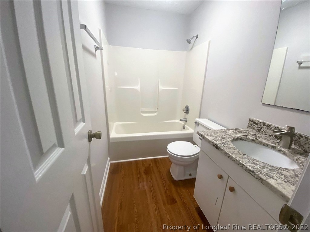 944 Flintwood Road Fayetteville, NC 28314 - Photo 24 of 50 a bathroom with a granite countertop sink toilet a mirror and shower