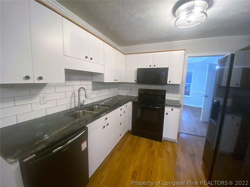 944 Flintwood Road Fayetteville, NC 28314 - Photo 26 of 50 a kitchen with granite countertop a refrigerator stove and sink