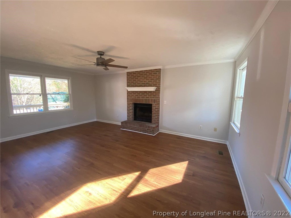 944 Flintwood Road Fayetteville, NC 28314 - Photo 36 of 50 an empty room with wooden floor fireplace and windows
