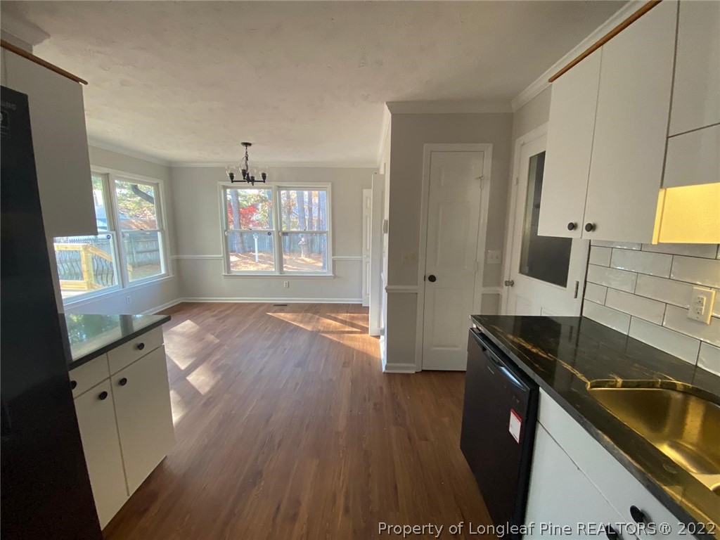 944 Flintwood Road Fayetteville, NC 28314 - Photo 38 of 50 a kitchen with granite countertop a sink stove and cabinets