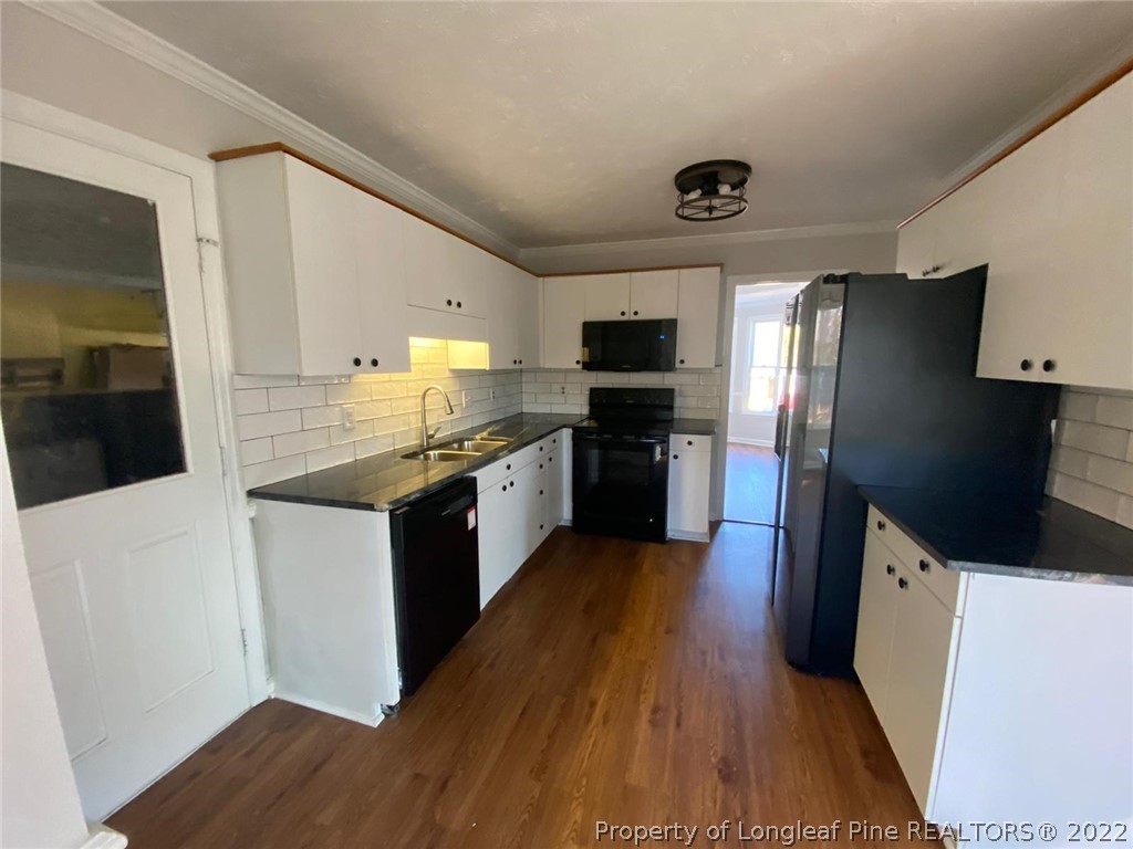 944 Flintwood Road Fayetteville, NC 28314 - Photo 40 of 50 a kitchen with stainless steel appliances a refrigerator a sink a stove top oven a counter space and wooden floor