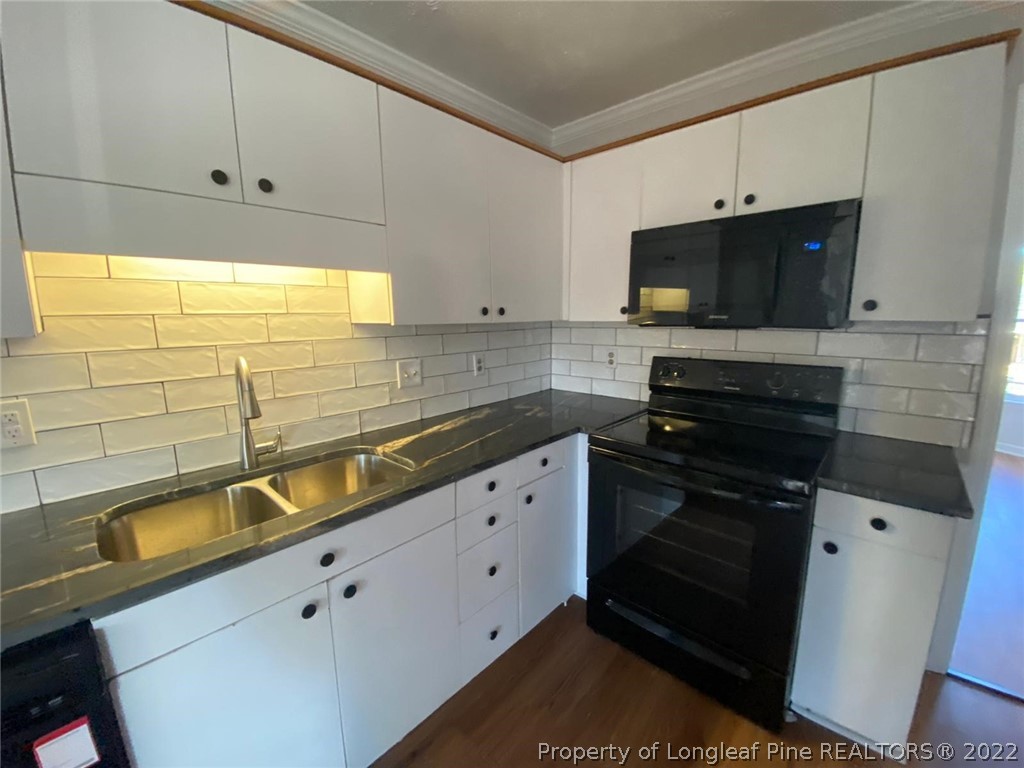 944 Flintwood Road Fayetteville, NC 28314 - Photo 41 of 50 a kitchen with stainless steel appliances white cabinets and a stove top oven