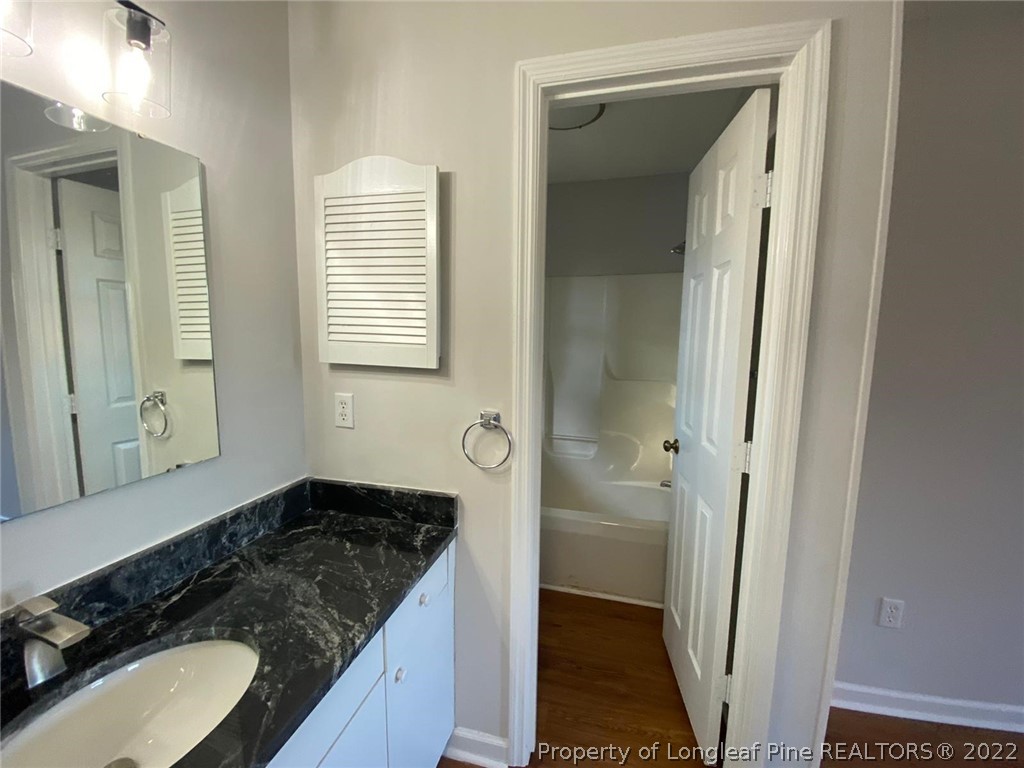 944 Flintwood Road Fayetteville, NC 28314 - Photo 47 of 50 a bathroom with a granite countertop sink and a mirror