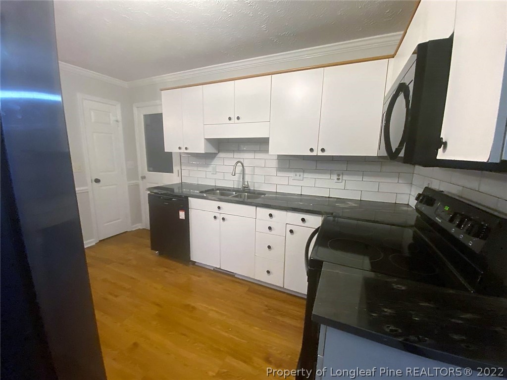 944 Flintwood Road Fayetteville, NC 28314 - Photo 6 of 50 a kitchen with a sink stove and cabinets